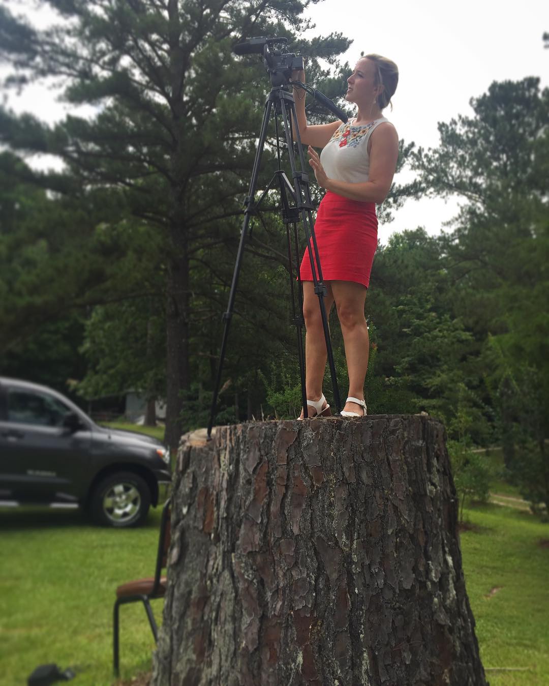 Candace on a stump with a camera